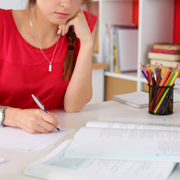 woman student sitting at desk at home studying