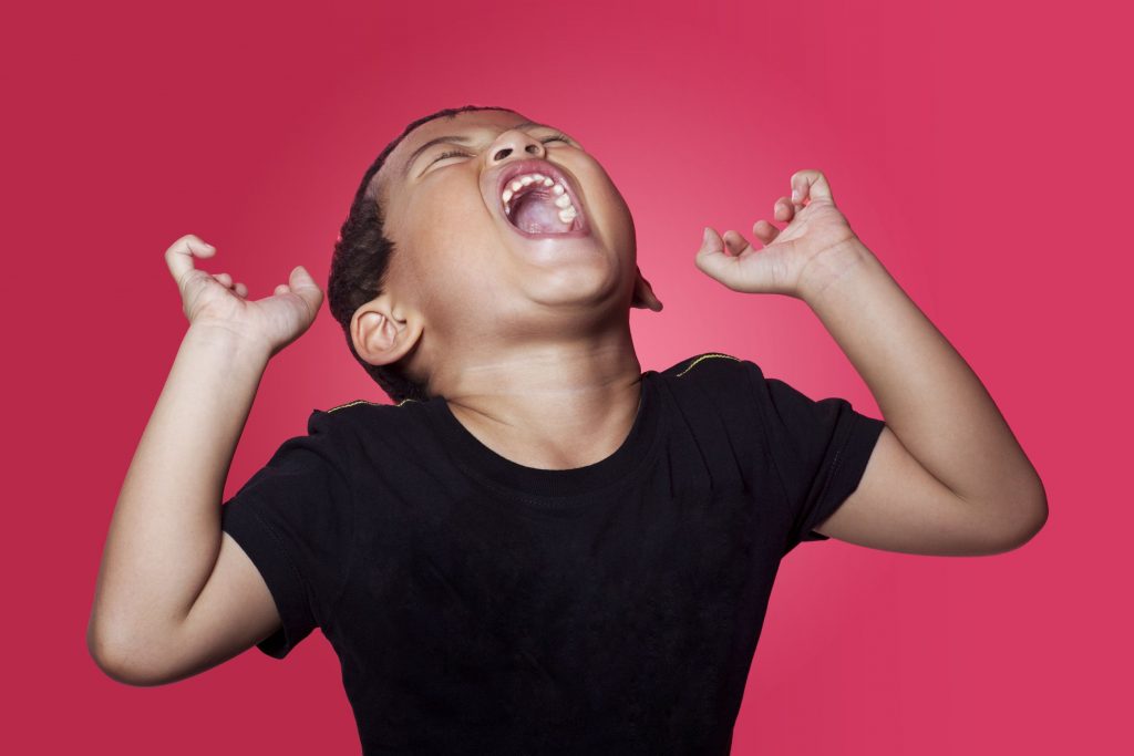 Angry child yelling with hands in the air