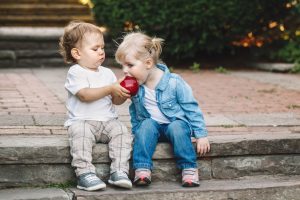 Small children sharing an apple