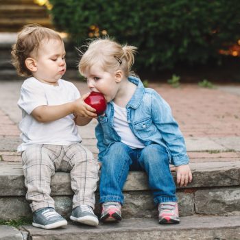 Small children sharing an apple